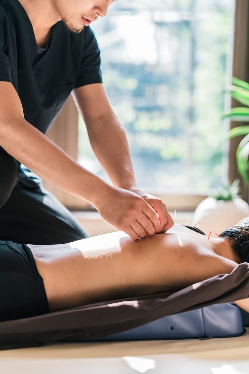 Acupuncteur travaillant sur le dos dun patient