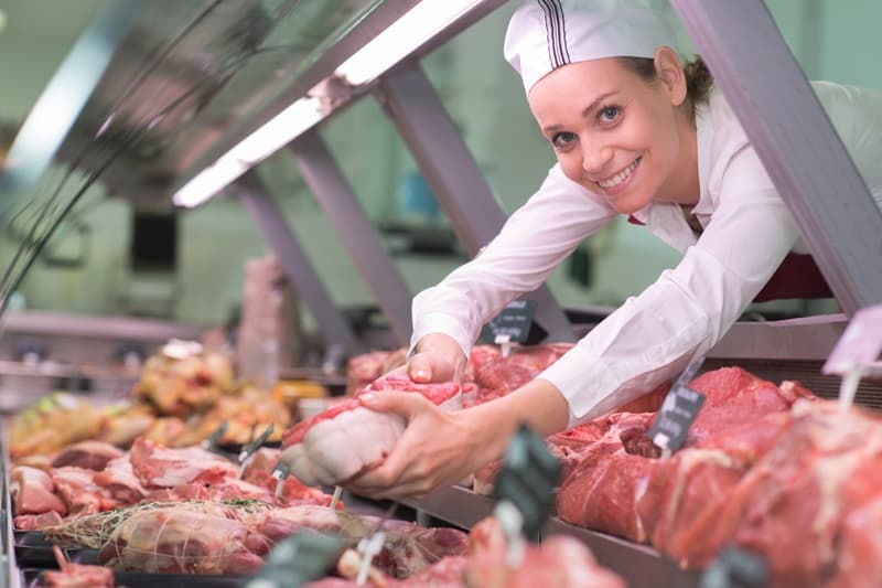 Bouchère plaçant la viande