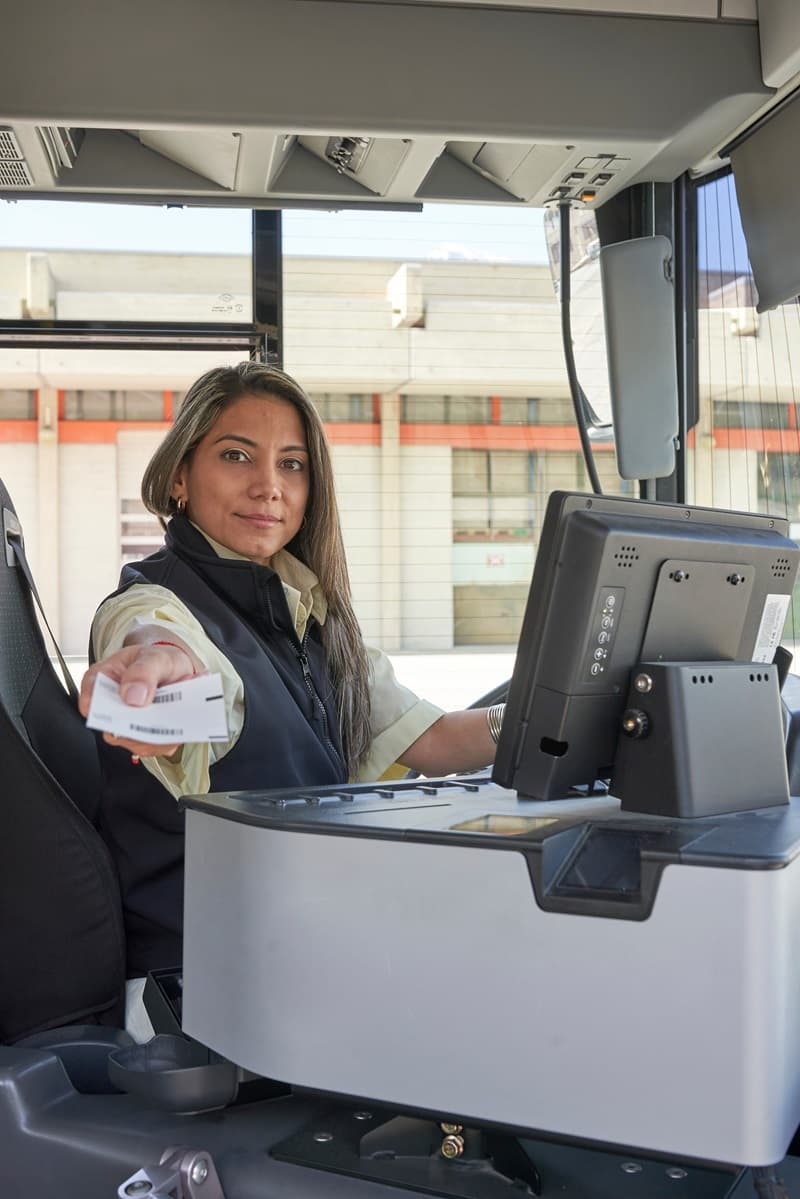 Chauffeur de bus de ville femme qui tend un titre de transport