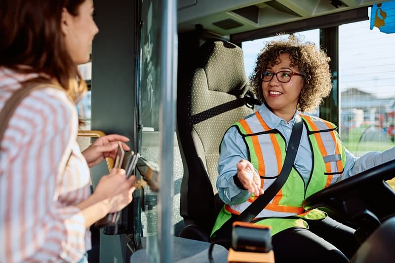 Chauffeur de bus discute avec une passagère