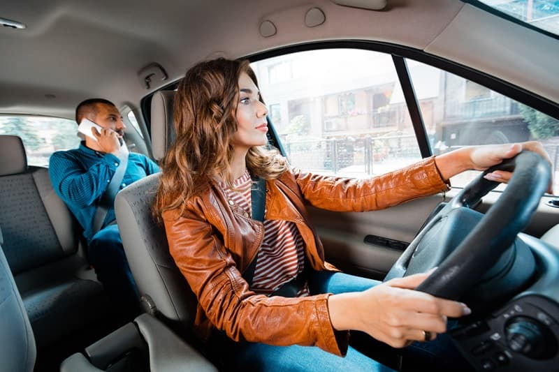 Chauffeur de taxi femme conduisant un client