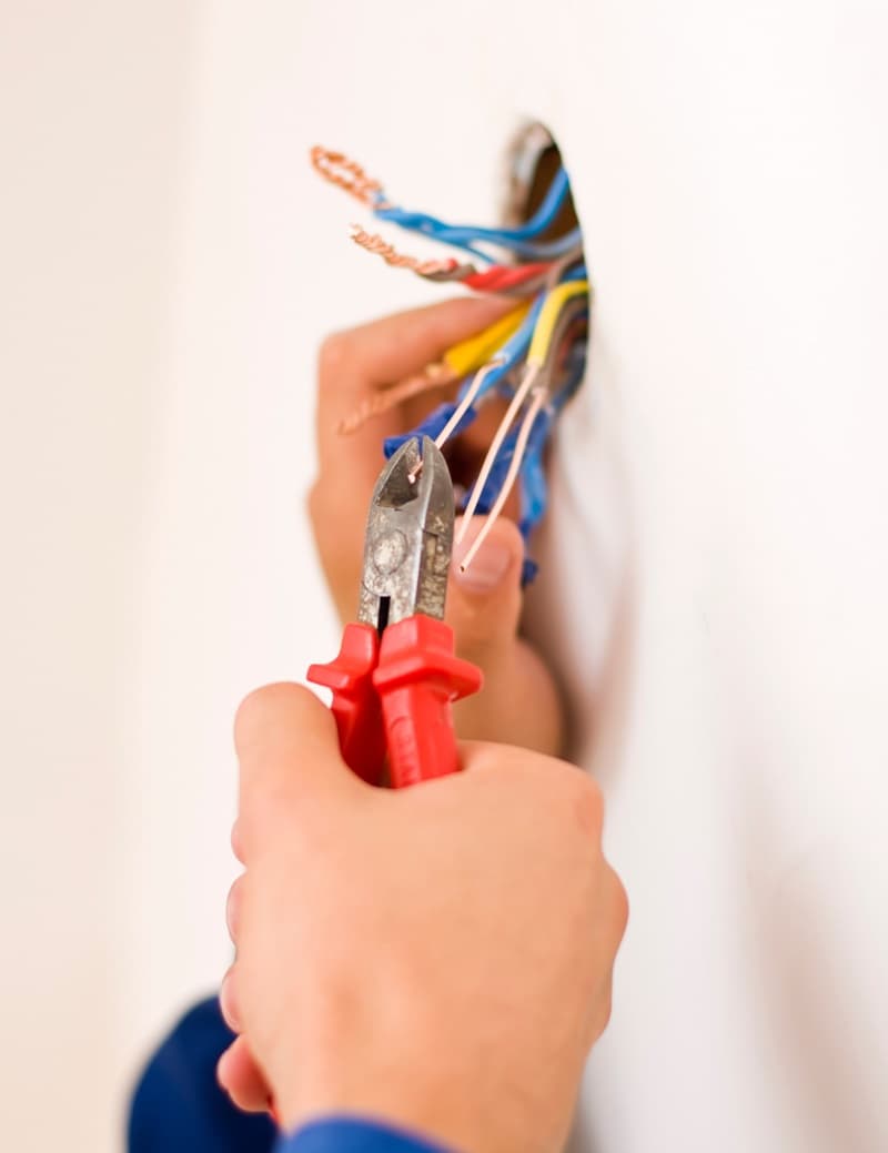 Mains dun électricien qui dénudent des cables