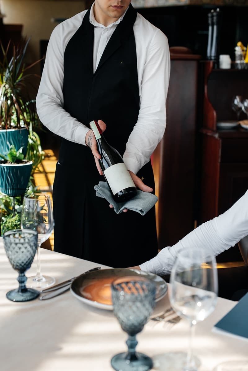 Sommelier qui présente une bouteille à table