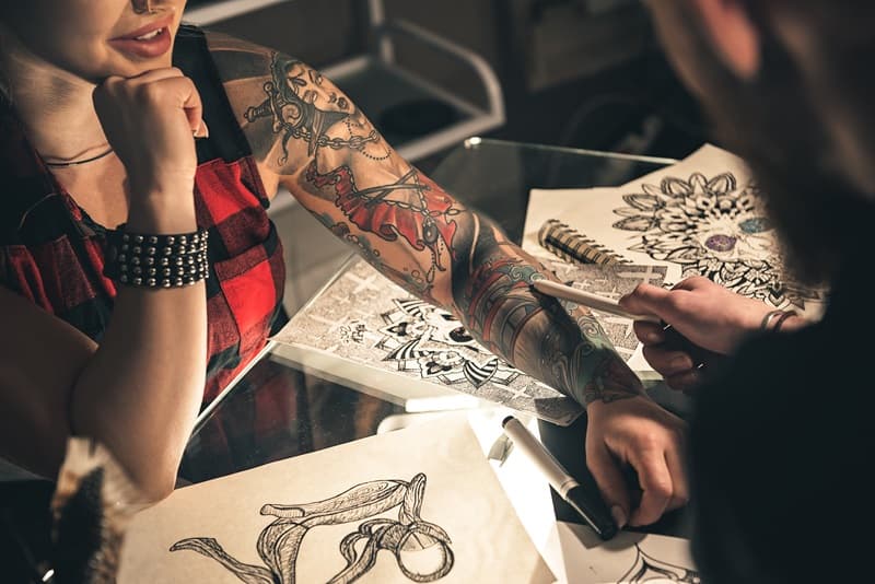 Tatoueur qui analyse le tatouage dun bras